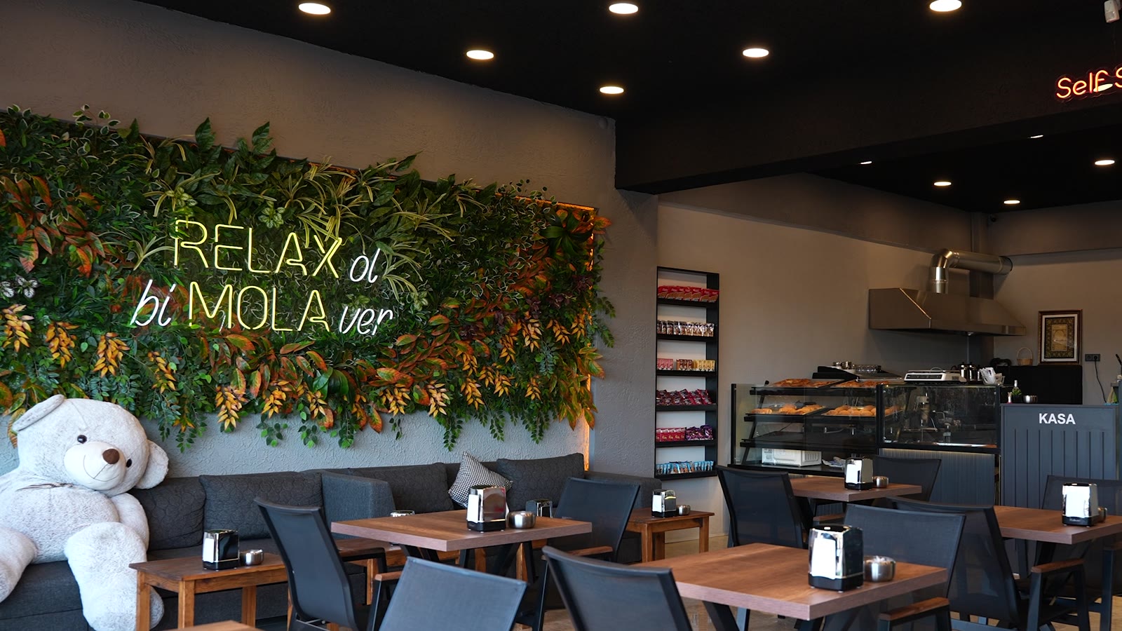 Yeşil duvar, neon yazı ve koltuklu oturma alanı